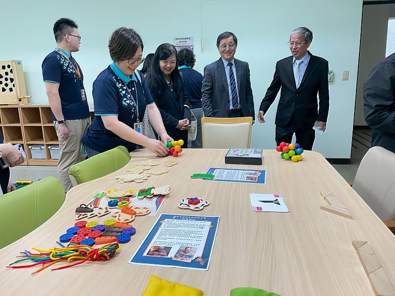 參訪團成員對「智慧樂齡健康教室」的教材與輔具感到好奇。