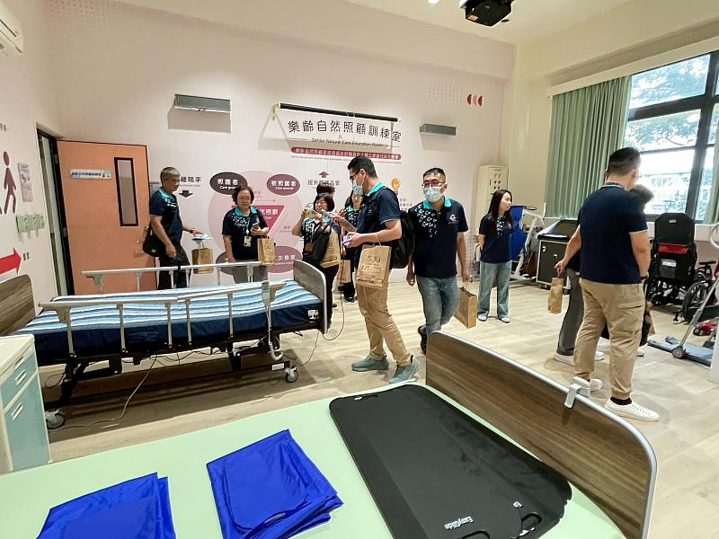 參訪團參觀「樂齡自然照顧訓練室」的相關設備，包括智能AI均壓床墊等設施。