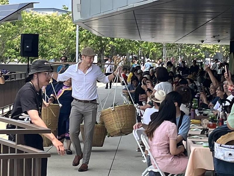 圖4 臺灣客家文化館賞桐食在地，由美籍歌手賈斯汀攜手苗栗在地大襟客文化藝術團成員挑擔宴席所使用的在地食材入場