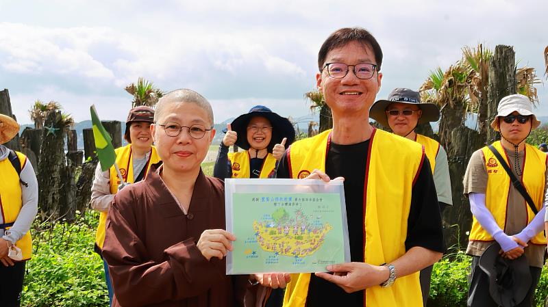 靈鷲山新北B區監院妙依法師（左）與慈心有機農業發展基金會種樹專員康家銘（右）共同展示植樹地圖。（圖由靈鷲山佛教教團提供）