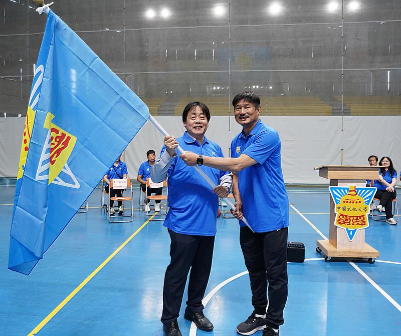 王子奇校長授旗給體育室余清芳主任，期盼全體選手為文化爭光。