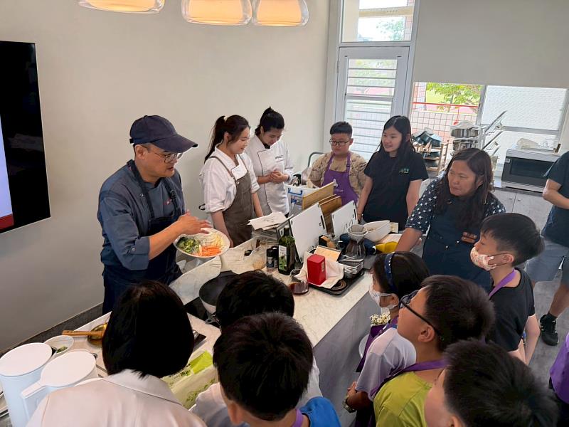 餐飲系教師向孩童示範料理製作教學。
