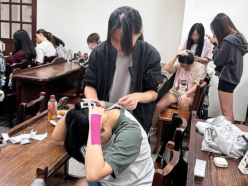 南華大學舉辦貼紮實作課程,學生互相進行肩頸酸痛貼紮實作練習。