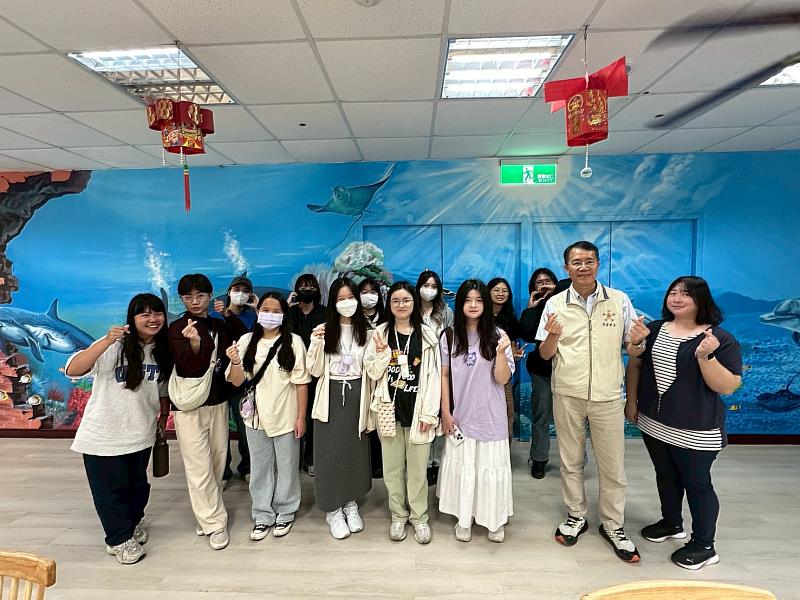 松柏堂堂長劉庭㚤（右1）與輔導組組長林崇誠（右2）與學生在巨型壁畫前合照。