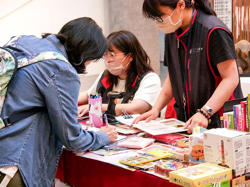 活動現場吸引親子家庭與遊客停下腳步詢問，館員親切協助民眾填寫資料、介紹圖書館資源，讓閱讀服務更加貼近日常生活。