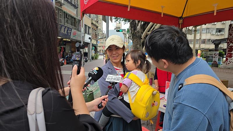 樂園忠實小粉絲與家長一同來到三角公園，開心地領取由主辦單位贈送的奇幻島全日暢玩票。