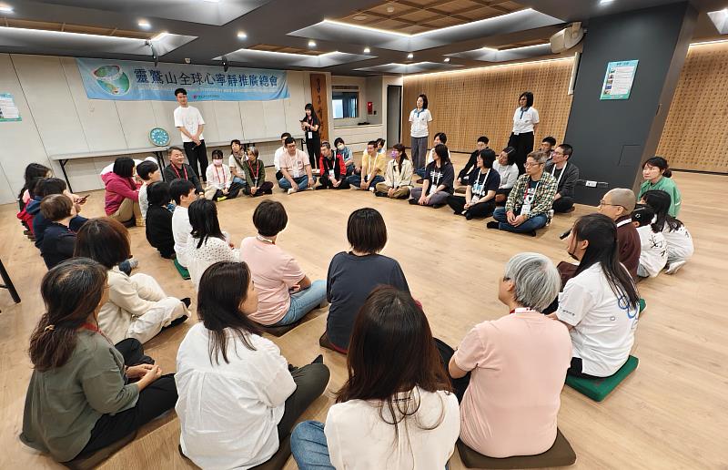 課程圓滿後，由法師引導全體學員席地而坐分享收獲與感悟。（圖由靈鷲山全球心寧靜教師團提供）