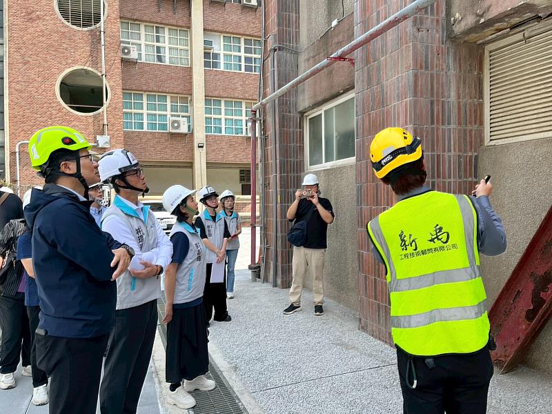 副市長林琨瀚偕同各單位人員共同視察光華國中信義樓1樓外牆現況。