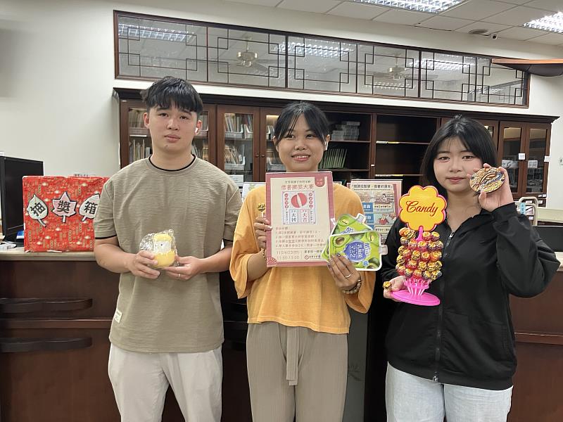 南華大學響應世界閱讀日，辦理「借書擲筊大賽」推廣閱讀，讀者擲出聖筊獲好禮歡喜合影。