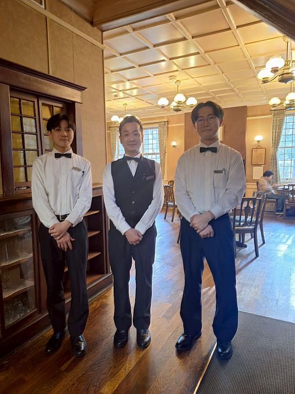 姿勢端正、面帶微笑，展現出日本服務業一貫的專業與禮儀。