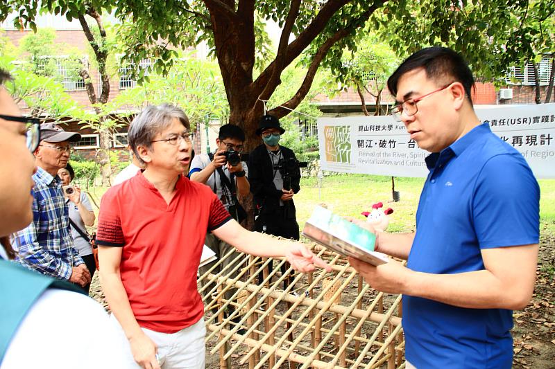 創媒學院邱國峻院長（左）向環保部長彭啓明（右）解說竹籠茨的故事。