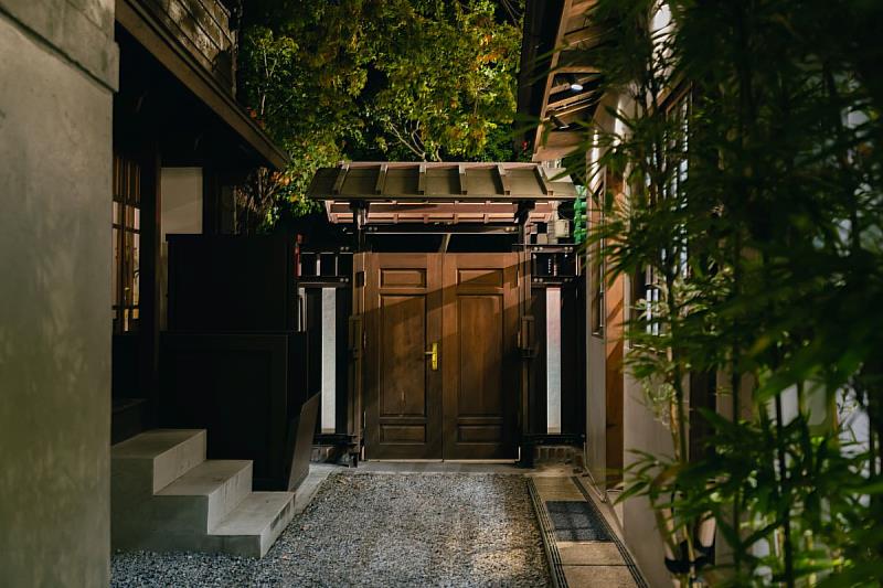 延續日式官舍的建築語彙，低調的木質大門與石徑，營造出隱身於巷弄間的當代沙龍私密感。（地點：樂埔薈所）