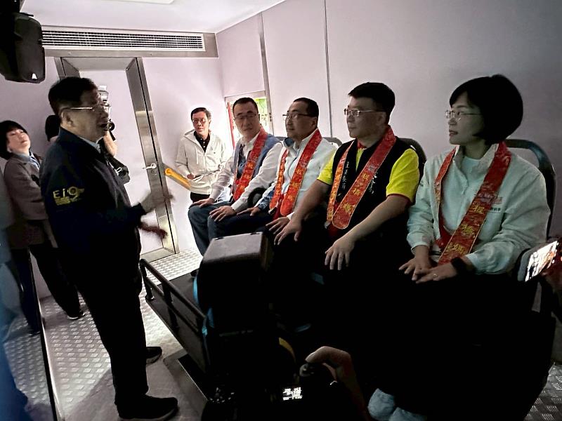 新北市政府消防局局長陳崇岳向慈惠宮主委賴春穆、侯友宜市長、市長候選人李四川副市長及市長候選人蘇巧慧立法委員說明最新型地震體驗車功能。