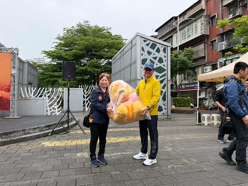 第二救災救護大隊曾天柔大隊長頒發摸彩獎品給參與活動的民眾