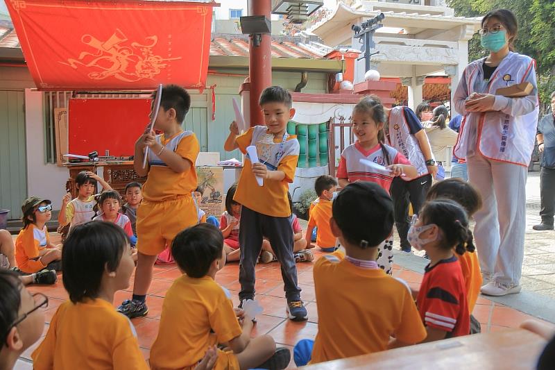 幼童熱中的參與扮演神明角色的互動遊戲情景。