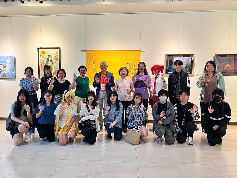 南華大學視設系舉辦「與夢共舞」系展，高俊雄校長（後排左5）逐一參觀作品，學生導覽介紹創作理念。師生合影留念。