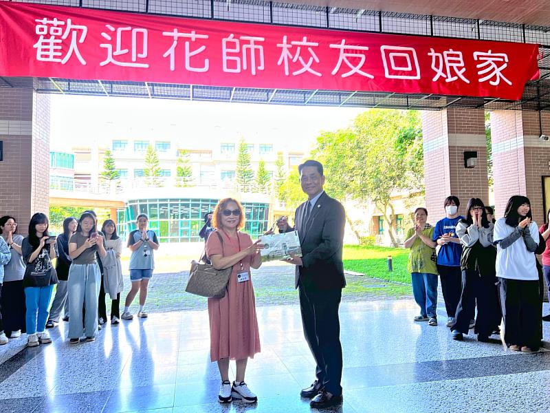 徐輝明校長與55級代表姚淑英互贈禮物。