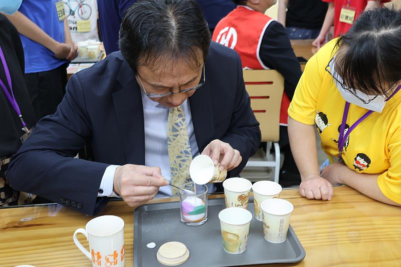 華南產險長官在服務對象的帶領下，一步步完成繽紛的沙蠟創作，享受手作的樂趣。