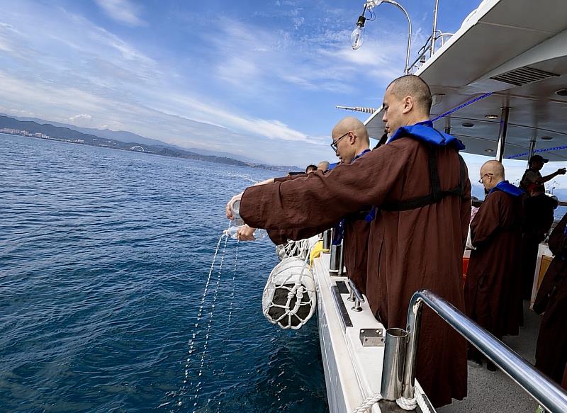 在〈大悲咒〉法音中，將大悲水灑向大海，為2萬4千尾真鯛魚苗祈福放流。（靈鷲山佛教教團提供）
