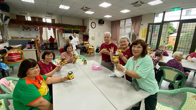社區長輩開心展現在元培食科系師生協助製作完成的醃漬鳳梨成果。