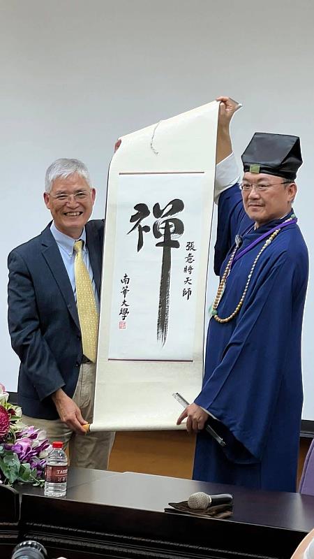 南華大學舉辦寺廟文化與管理論壇，高俊雄校長（左）致贈墨寶給張意將天師（右）。