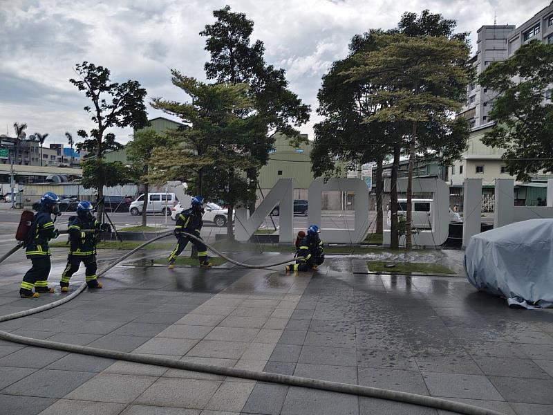 企業義消結訓演練進行滅火攻擊及水霧防護操作。