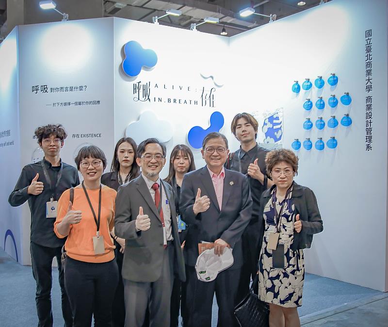 校長任立中走訪商業設計管理系展場，與學生團隊交流並合影。攝影：林冠程