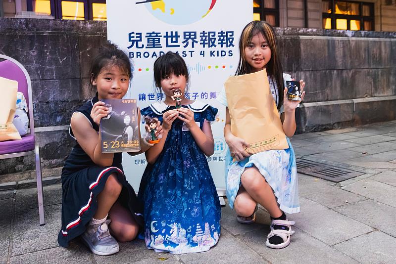 參與活動的孩子們手拿演出節目冊、小卡與樂團紀念公仔，留下美好回憶。