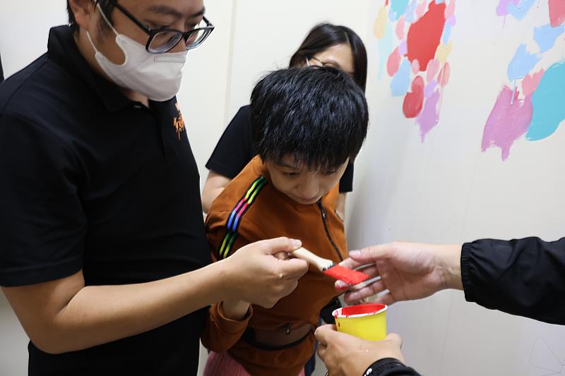 教會志工與教保員一對一陪伴服務使用者進行彩繪創作。