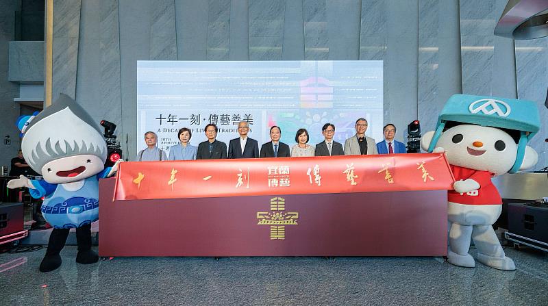 全聯善美的文化藝術基金會以傳承為核心，致力打造兼具文化與社會價值的永續平台，與會貴賓與吉祥物同台展示卷軸。左至右：人間國寶  李秉圭老師、全聯善美的文化藝術基金會 唐美雲董事、全聯善美的文化藝術基金會 吳靜吉董事、仰山文教基金會 游錫堃創辦人、全聯福利中心暨善美的文化藝術基金會 林敏雄董事長、文化部國立傳統藝術中心 陳悅宜主任、交通部觀光署 黃易成主任秘書、文化部國立臺灣工藝研究發展中心 陳殿禮主任、全聯善美的文化藝術基金會 林子文常務董事。