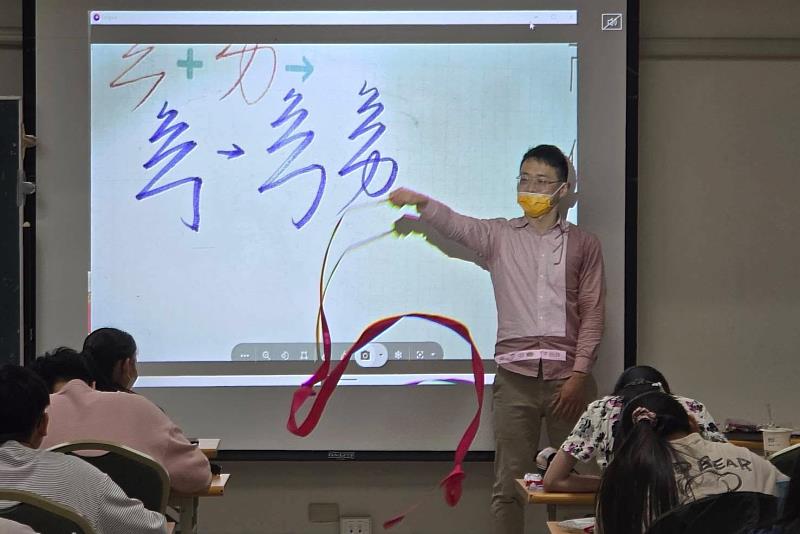 南大國文系邀請葉曄書法家運用甩紙棒與彩帶示範運筆節奏，帶領學生從書寫動作中體會硬筆書法的線條與結構美感。
