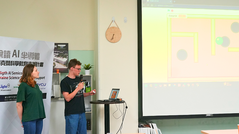 Ukrainian student Kristina Lanoshchuk (left) and her classmate demonstrate the concept and gameplay behind their self-designed project using handheld sensors during the presentation session.