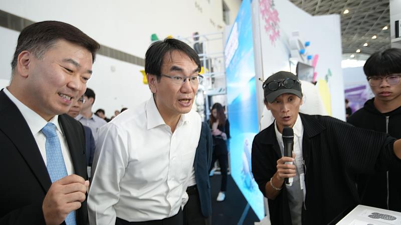 視傳系焦聖偉老師（右2）為李天祥校長（左1起）、數位發展部林宜敬部長介紹學生作品。