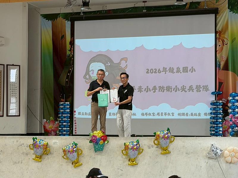 本勤益科大學務處軍訓室主任周國勳上校代表勤益致贈感謝狀給龍泉國小王銘男校長。