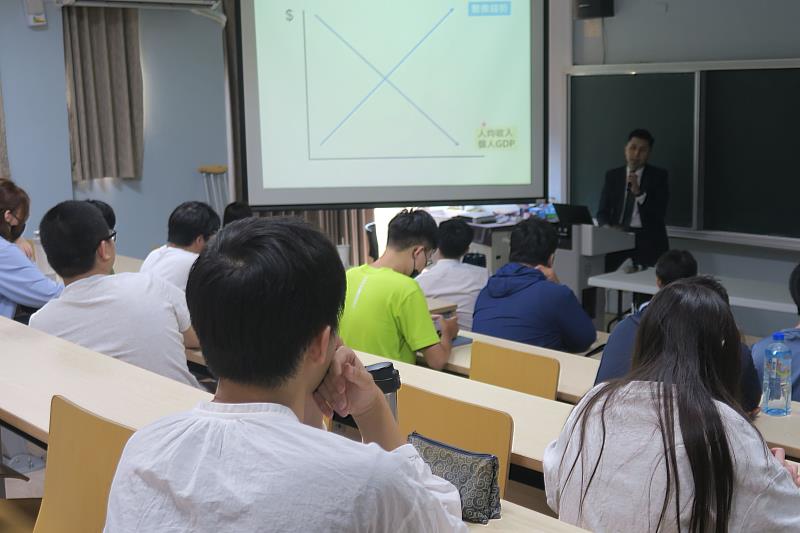 陳柏村經理以圖表說明醫療保障與經濟發展關聯，協助南大學生建立正確理財與風險規劃觀念。