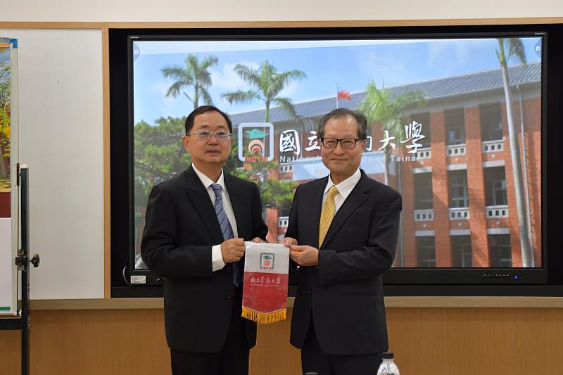 南大副校長侯志正與日本石川縣立大學代表交換紀念旗幟，象徵兩校友好情誼與交流合作。