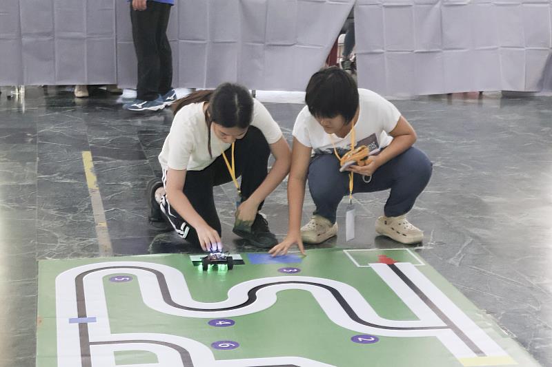 南區參賽學生於「任務計分賽」中專注調整機器人路徑與程式設定，展現邏輯思維與實作能力。