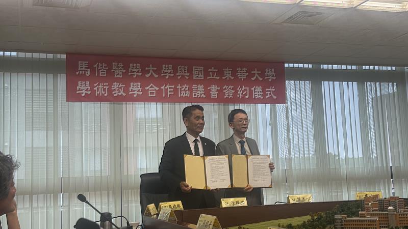 東華大學校長徐輝明（右）與馬偕醫學大學校長葉宏一（左）共同展示簽署完成之學術教學合作協議書。