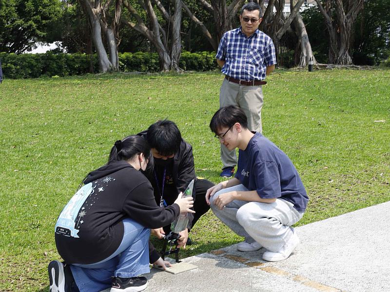 在授課老師，航太系蕭富元教授指導下，學生在書卷廣場進行水火箭試飛。（圖／淡江大學提供）