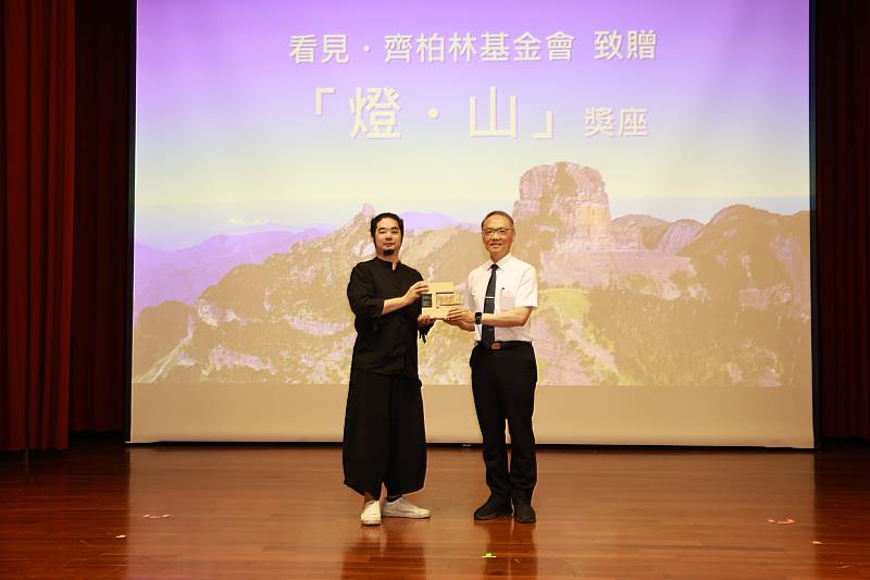 看見．齊柏林基金會董事齊廷洹（左）代表致贈燈．山獎座給慈濟慈善事業基金會顏博文執行長（右）感謝慈濟連續三年攜手舉辦齊柏林飛閱台灣攝影獎。（看見．齊柏林基金會提供）