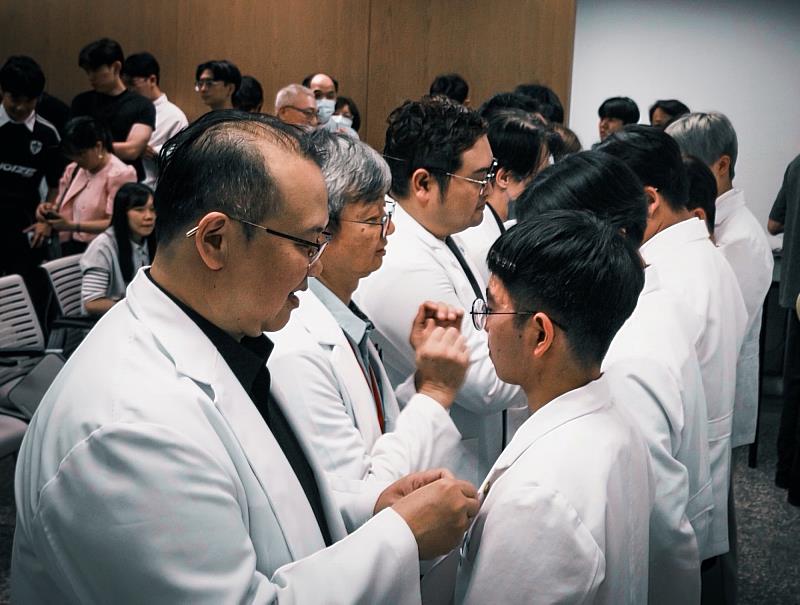 在授袍儀式中，師長親手為學生佩戴象徵亞大視光精神的系徽，傳承專業與責任。