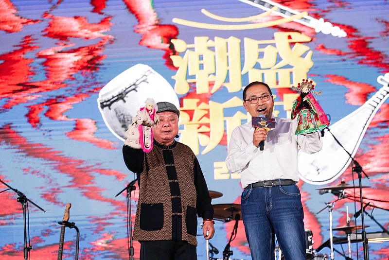 2026潮盛新莊「庄頭開唱」音樂會,6日於新莊新月廣場登場。新北市長侯友宜與新西園掌中劇團許正宗團長,手持布袋戲偶,寓意傳統藝術與創意在新莊持續傳承。