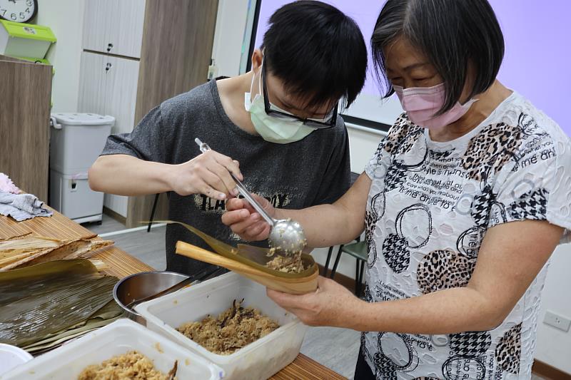 三峽國光身障日照中心舉辦端午包粽活動，長輩與服務對象互動有愛、場面溫馨。