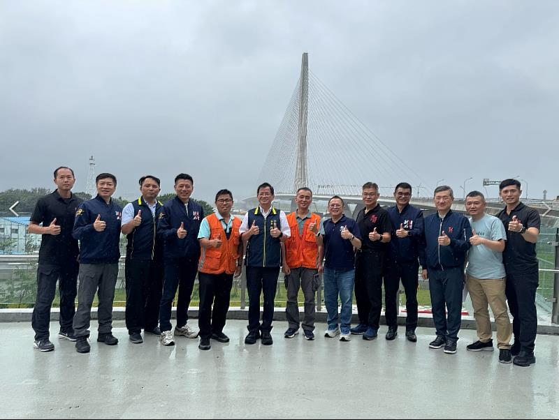 新北市政府消防局與交通部公路局北區養護工程分局於淡江大橋橋梁管理中心交流後合影留念；左起為北區養護工程分局主任工程司楊秉順、中間處為新北市政府消防局局長陳崇岳、右起為景美工務段段長張建智。