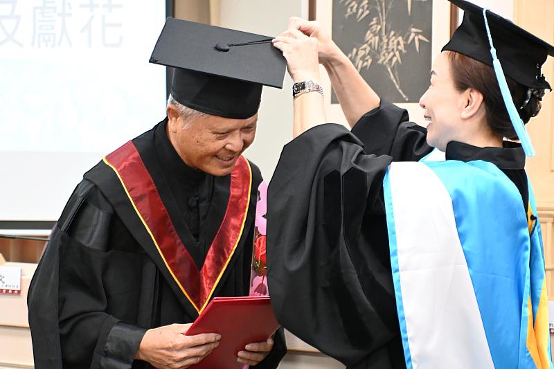 南華大學賴淑玲副校長（右）為樂齡大學結業典禮發表感言代表李清潭學員撥穗。