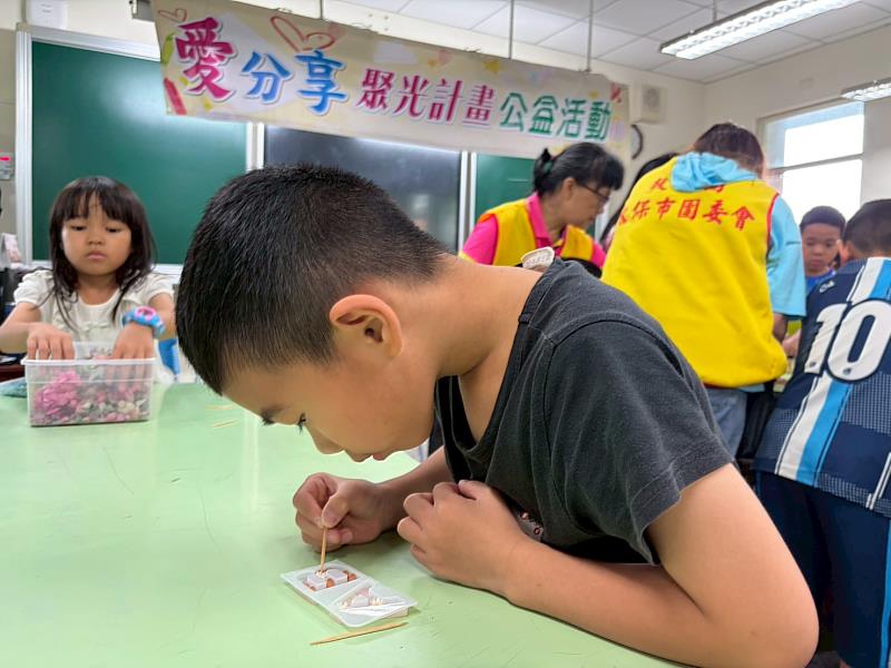 學生認真專注放入點綴物至手作品的模型