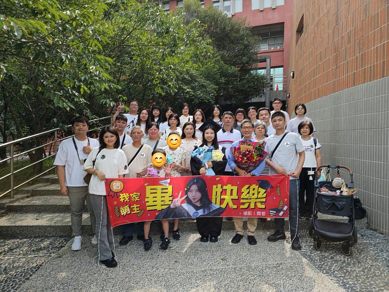 暨大114年度畢業典禮國企系畢業生張彧萌(著學士服),與25位家族成員和一隻寵物毛孩組成的「超重量級應援團」合影。
