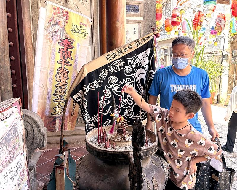 【傳統過爐・祈福安康】參與活動的父子檔手持親手完成的馬仔香，於金華府進行傳統香包「過爐儀式」，誠心祈求金運與幸福加滿，展現在地信仰與文創的完美結合。