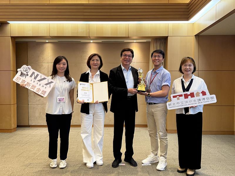 新北市立淡水古蹟博物館勇奪美國尼克斯獎金獎,新北市文化局長張䕒育(左2)偕同淡水古蹟博物館館長蔡美治(右1)及同仁於市政會議向新北市副市長劉和然(中)獻獎,並與全體新北市民分享喜悅。