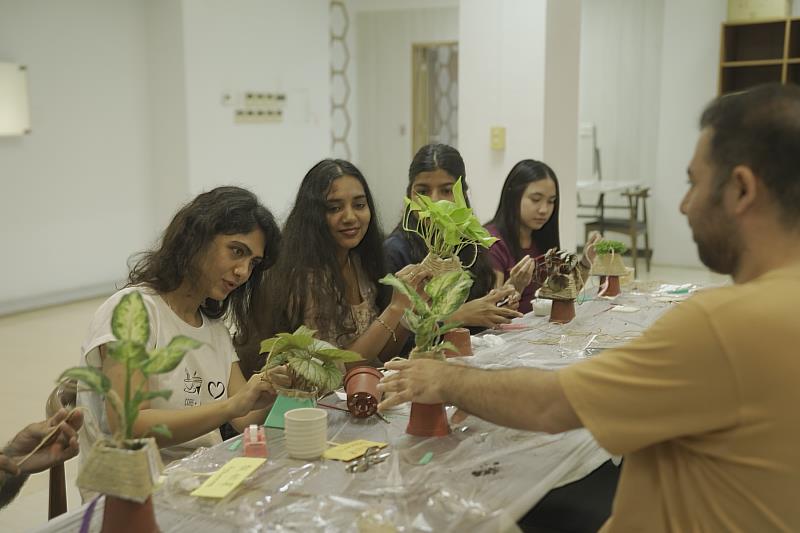 學生專注進行端午創意盆栽手作，透過麻繩、自然素材與綠色植物完成作品。
